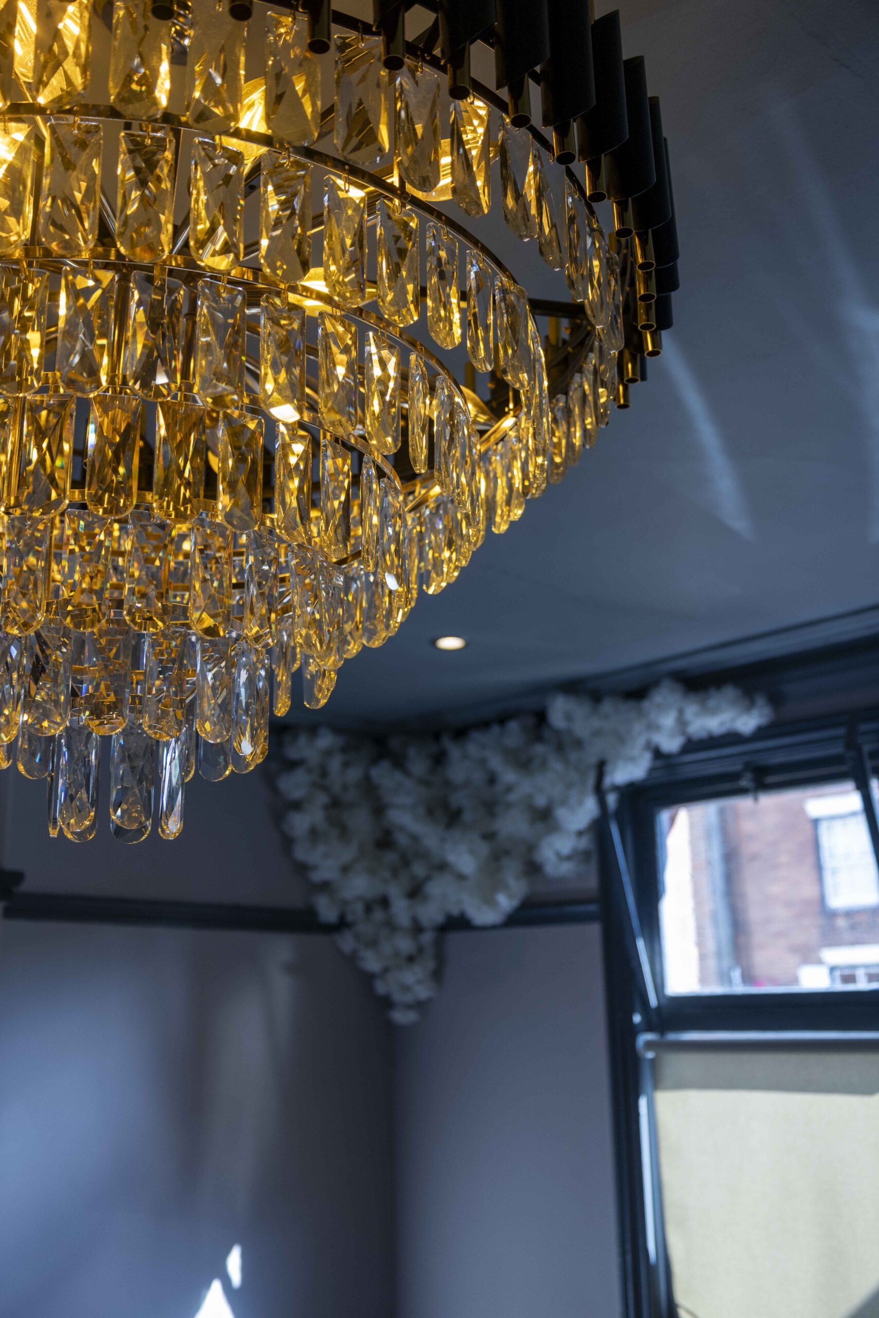 Close up of crystal Chandelier and blossom on ceiling