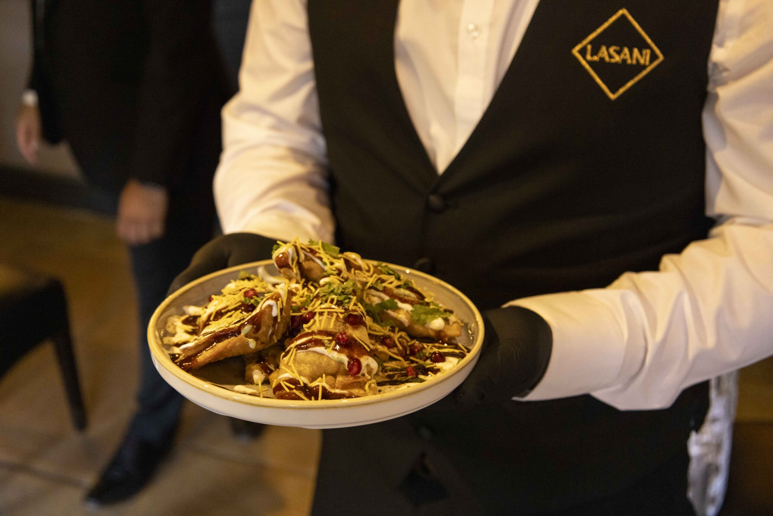 Lasani Waiter serving a dish to guests